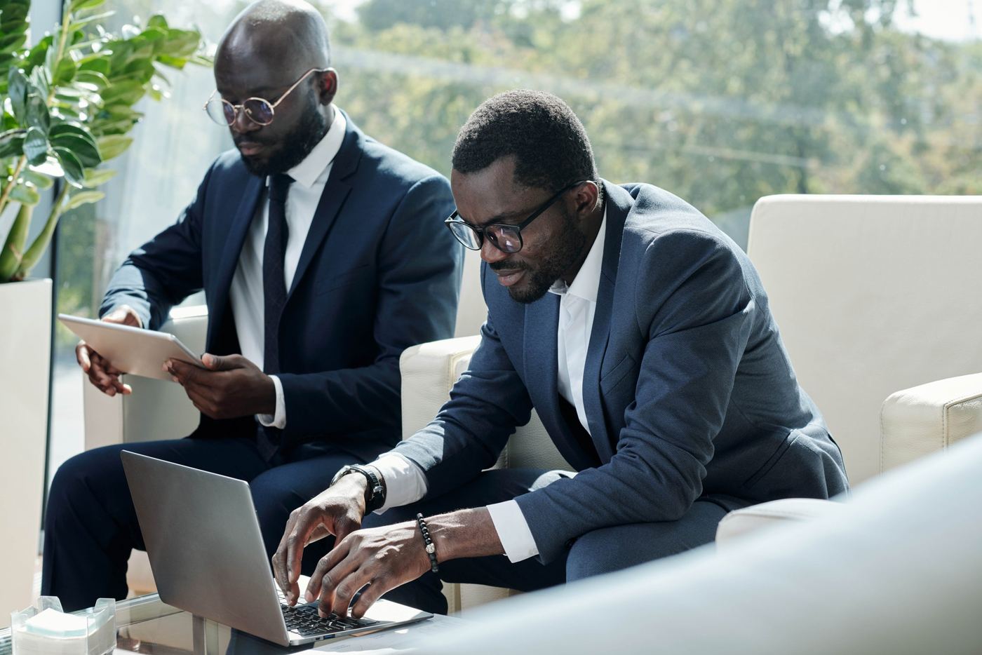 Two professionals reviewing work on a laptop